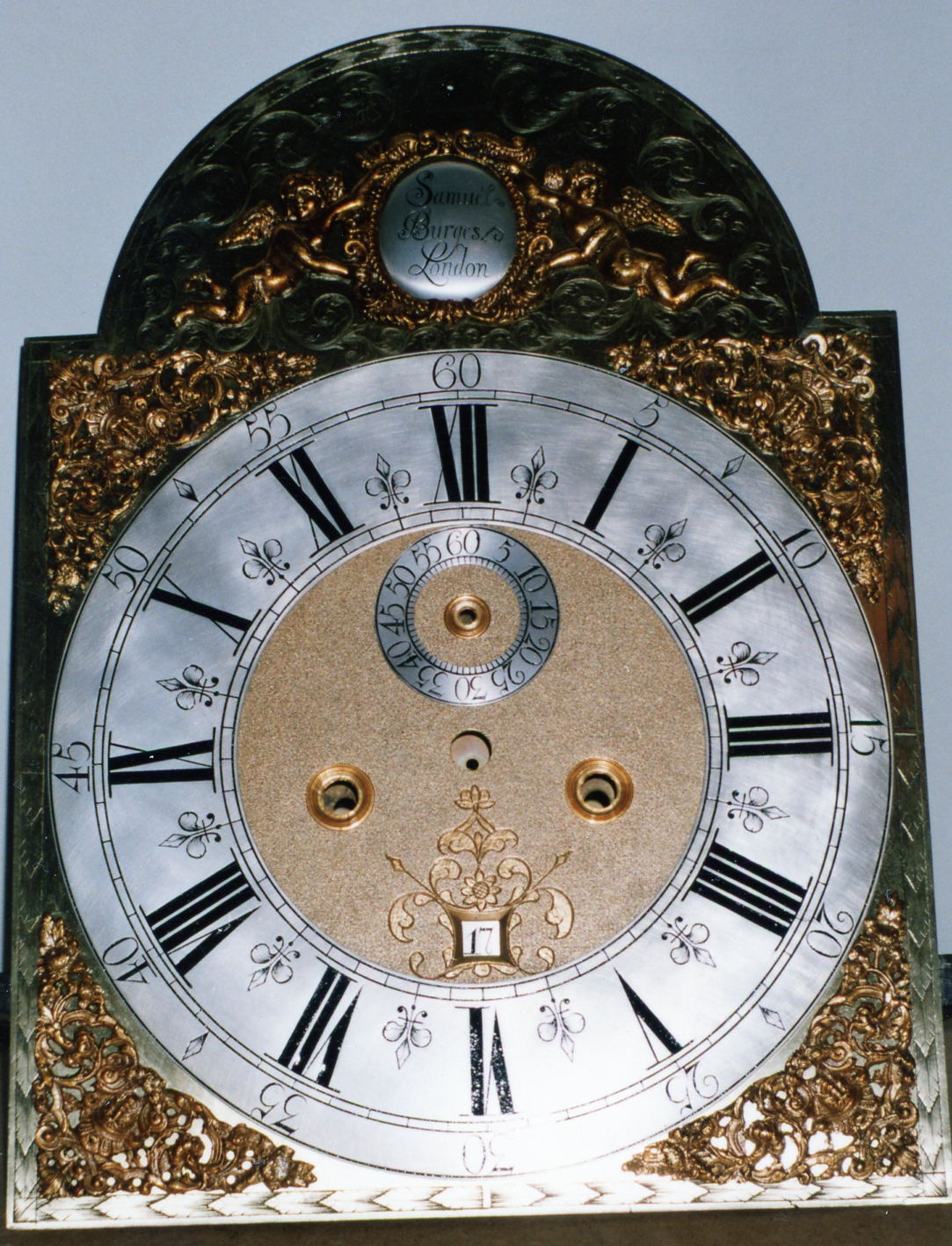 8-day arch dial clock by  clockmaker Samuel Burgess, London 1720 - 1730. Some features help to date this antique clock.